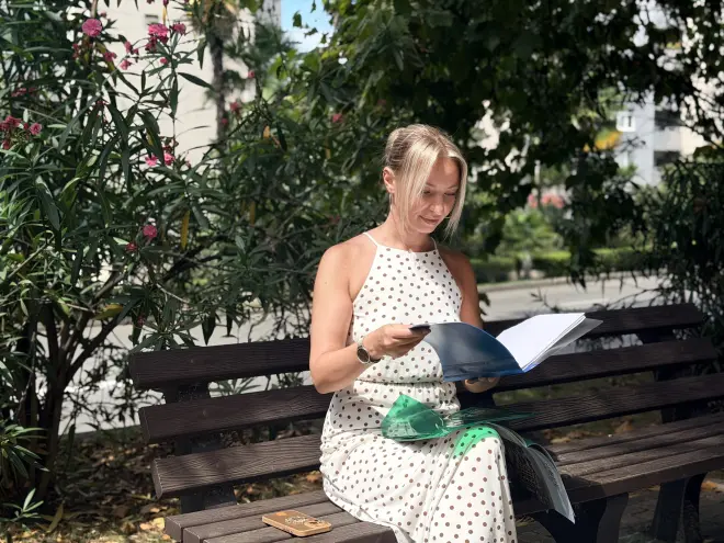 Иллюстрация из медиатеки ГРЦ. Девушка сидит на скамейке и рассматривает журнал.